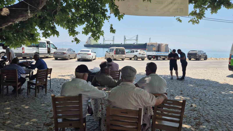 Köy kahvesinden karaya oturan gemiyi izliyorlar